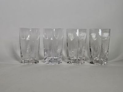 quatre verres transparents posés les uns à côté des autres sur une surface blanche