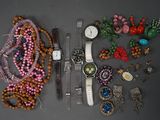 de nombreux bijoux posés sur une table, parmi lesquels une montre et un bracelet