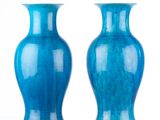 pair of blue vases sitting on a white surface against a white background