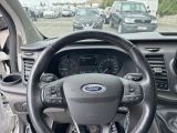 a steering wheel and dashboard of a car in a parking lot