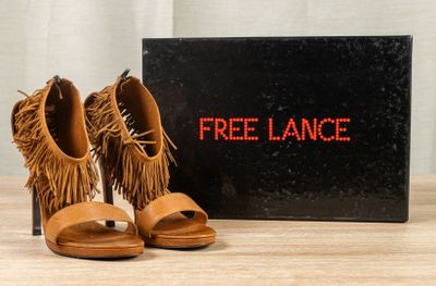 tan fringe sandals with a black box on a wooden table