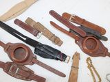 a lot of different types of leather belts on the table