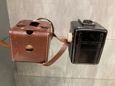 un petit appareil photo fixé à un étui marron
