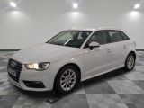 L'Audi blanche est garée dans une grande pièce au sol carrelé en damier.