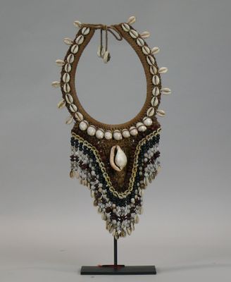 a close up of a necklace on a stand on a white background