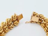 an image of a gold chain bracelet on a white surface
