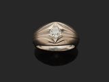 un gros plan d'une bague sertie d'un diamant, posée sur une surface noire