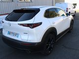 the rear end of a white mazda cx - hr parked in a parking lot