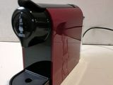 a red coffee maker sitting on a white table