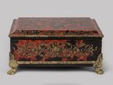 une boîte rouge et noire ornée de motifs dorés