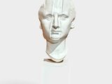 sculpture of a man ' s head on a white pedestal