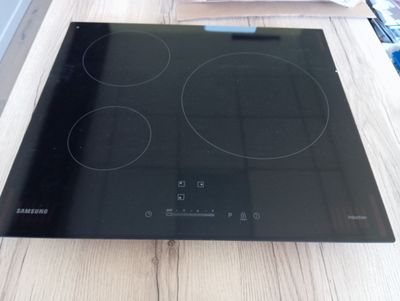 une plaque de cuisson noire posée sur une table en bois dans une cuisine