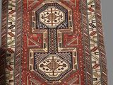 a red and blue rug with a geometric design on it