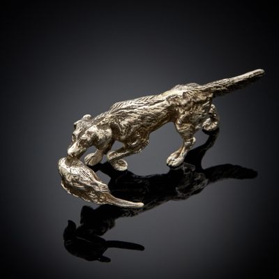 un gros plan d'une sculpture représentant un chien sur une surface noire