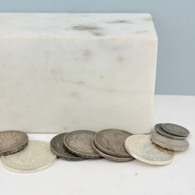 quelques pièces de monnaie sont posées à côté d'un bloc de marbre sur une table