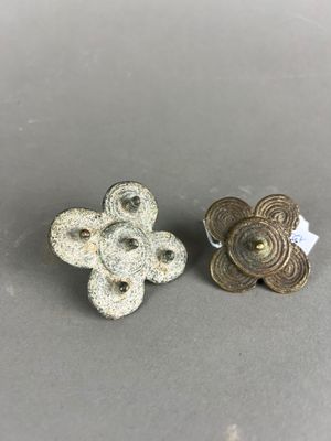 une paire de petits boutons métalliques sur une surface grise