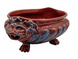 a red and blue planter with a lion head on it