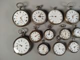 many different types of pocket watches displayed on a table
