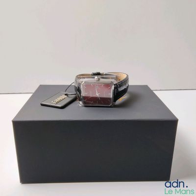 une boîte noire sur laquelle sont posés une montre et un téléphone portable