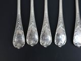six silver spoons and a fork on a black surface
