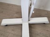 a white umbrella that is on a stand on the floor