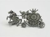 silver plated figurine of a horse drawn carriage with a man on it