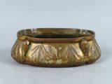 a gold colored planter sitting on a white surface