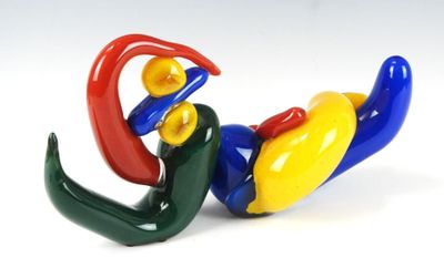 une figurine colorée représentant un oiseau perché au sol