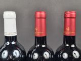 three bottles of wine with faces painted on them