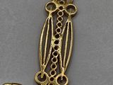 a close up of a gold necklace with a bird on it