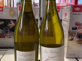 deux bouteilles de vin posées sur une table l'une à côté de l'autre