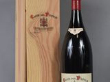 la bouteille de vin rouge se trouve à côté d'une caisse en bois