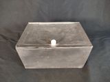 une vieille boîte en argent contenant une boule blanche sur fond noir