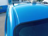 a blue car parked in a parking lot next to other cars