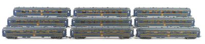 several gray train cars are lined up on a white surface