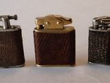 trois types différents de briquets sont alignés sur une surface blanche