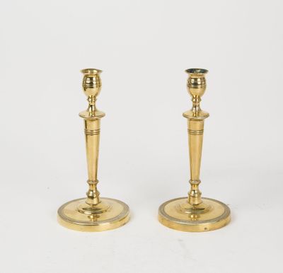 a pair of brass candlesticks on a white background