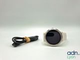a close up of a watch on a white surface with a cord