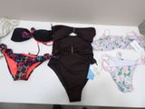 Plusieurs maillots de bain sont disposés sur une table dans une pièce