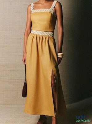 a woman in a yellow dress posing for a picture