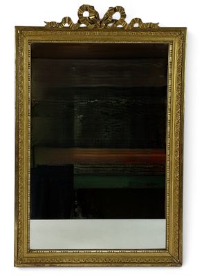 an image of a gold framed mirror hanging on a wall