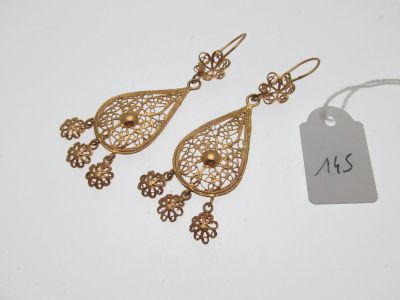 une paire de boucles d'oreilles dorées ornées de détails en filigrane