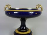 un vase bleu et or posé sur un socle