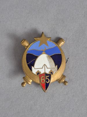 un insigne surmonté d'une étoile et un écusson orné d'une étoile