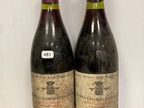 deux bouteilles de vin posées sur une table en verre, à côté d'une bouteille de vin