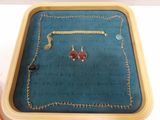 a wooden tray with a necklace and earrings on it