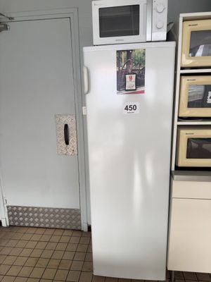 a white refrigerator in a kitchen with a microwave on top of it
