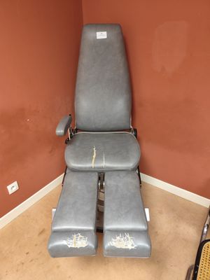 une chaise vide dans une pièce aux murs rouges et au sol marron