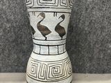 un vase blanc orné d'un motif noir et blanc