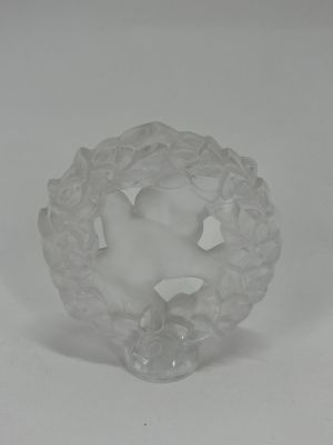 a white glass figurine sitting on top of a white table